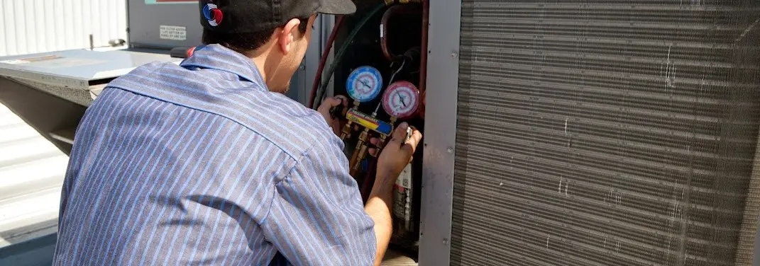 HVAC technician servicing a condenser unit in Cape Elizabeth