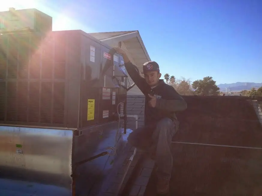 HVAC technician performing Heat Pump Repair on a rooftop unit in Cape Elizabeth
